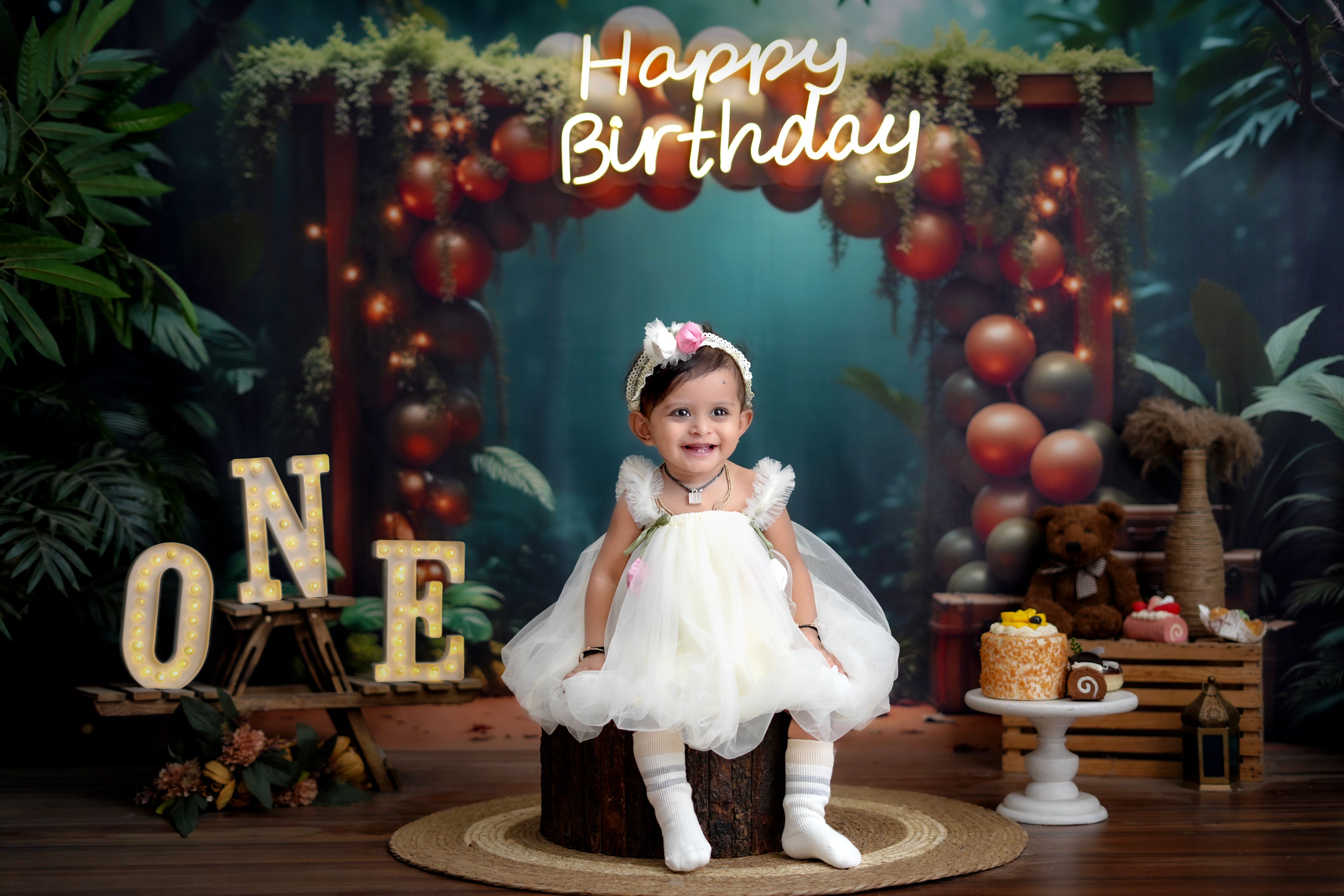 Charming photo of a baby girl celebrating her first birthday with festive decorations.