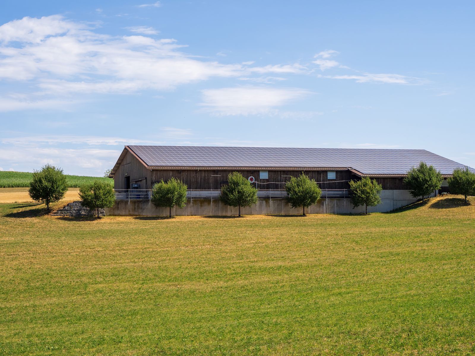 Solar-powered barn in a sunny rural landscape with green fields