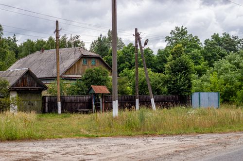 Free Old wooden house surrounded by greenery, showcasing rural countryside charm. Stock Photo