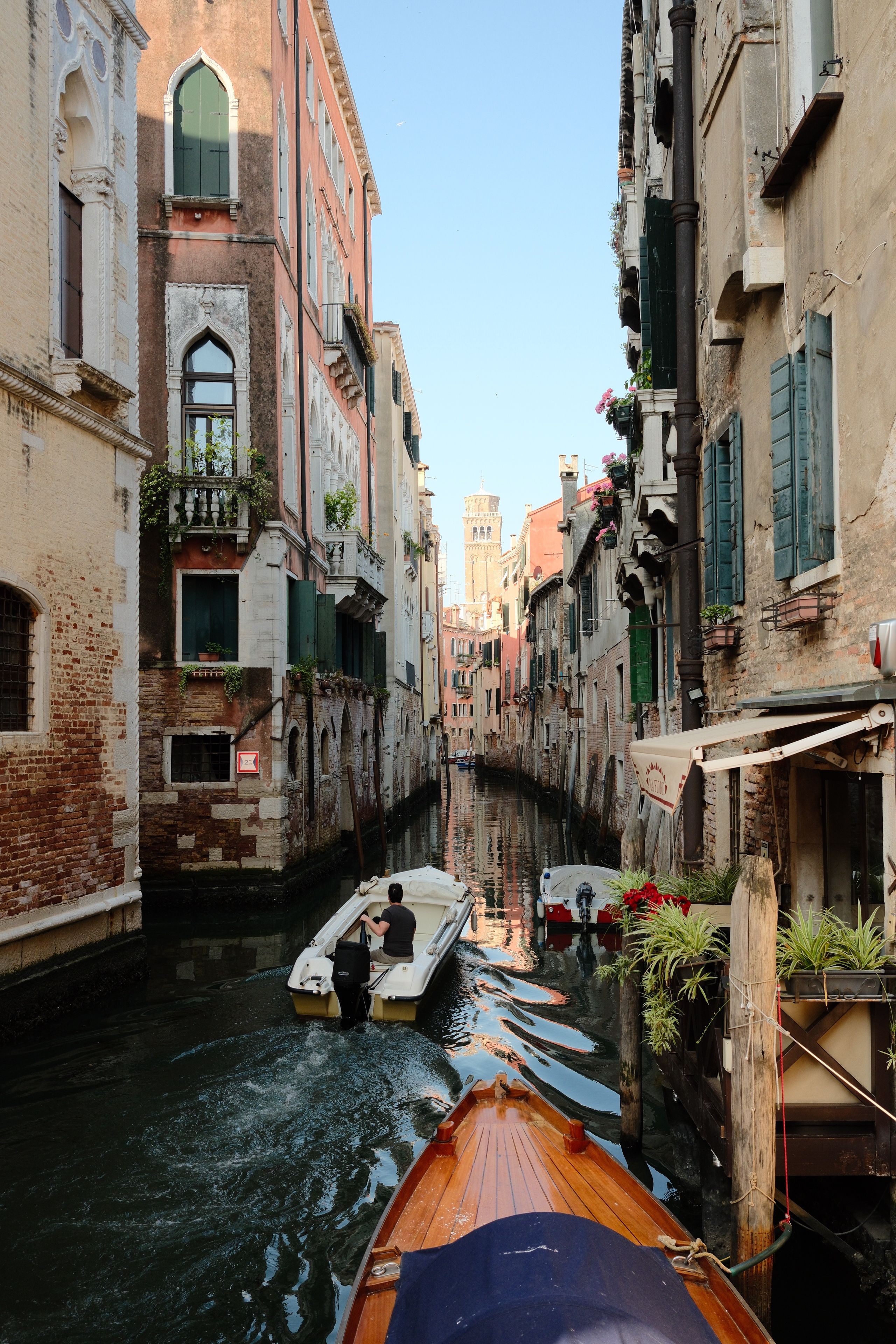 Tranquil view of boats navigating a picturesque canal in Venice.