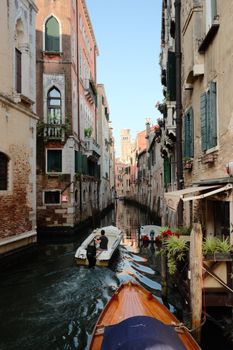 Tranquil view of boats navigating a picturesque canal in Venice.