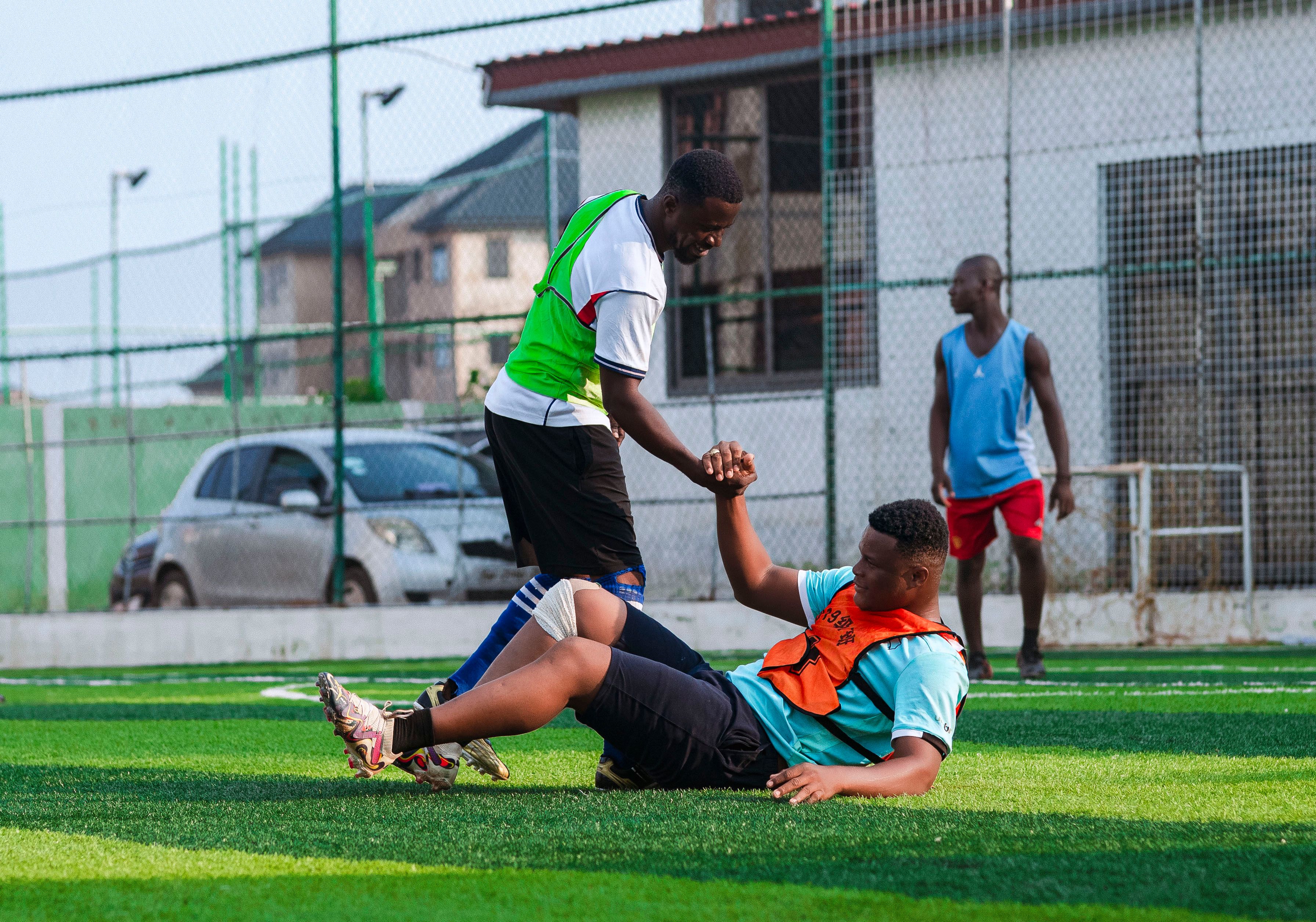 Two men playing soccer, showing teamwork and sportsmanship outdoors.