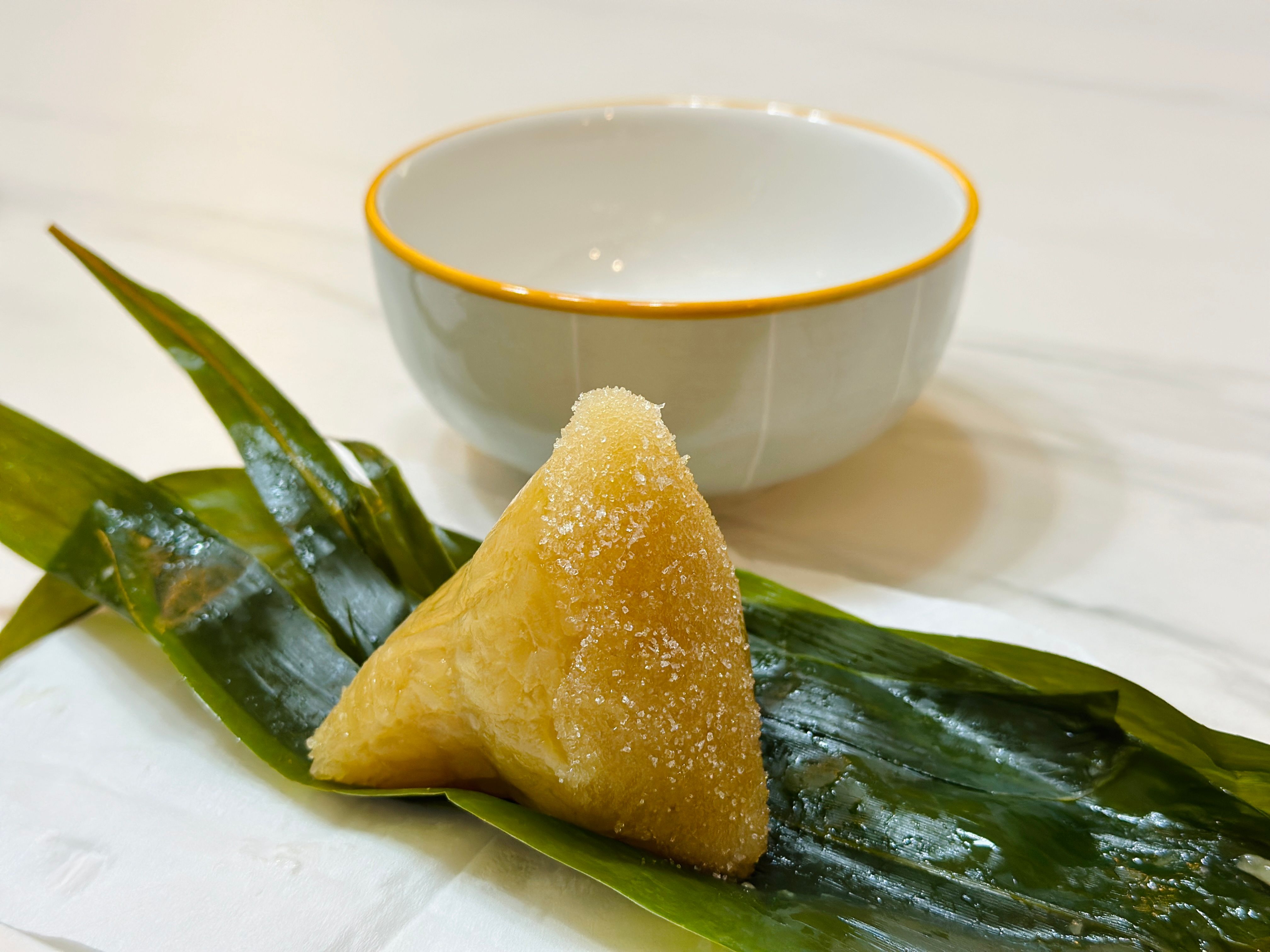 A mound of glossy white glutinous rice piled in a bamboo steamer lined with cheesecloth, with steam rising off the top.