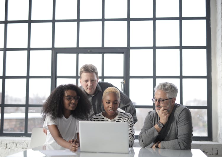 Concentrated Multiethnic Group Working On Laptop In Office