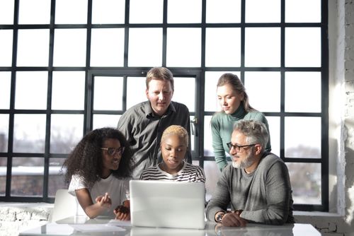 Free A diverse group of professionals collaborating on a project in a modern office setting with natural light. Stock Photo