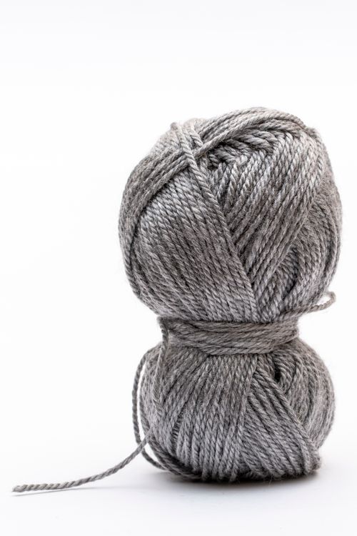 Free High-quality close-up image of a grey yarn ball on a clean white background, perfect for crafting visuals. Stock Photo