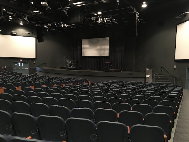 Empty Cinema Theater Hall With Black Chairs And Monitors