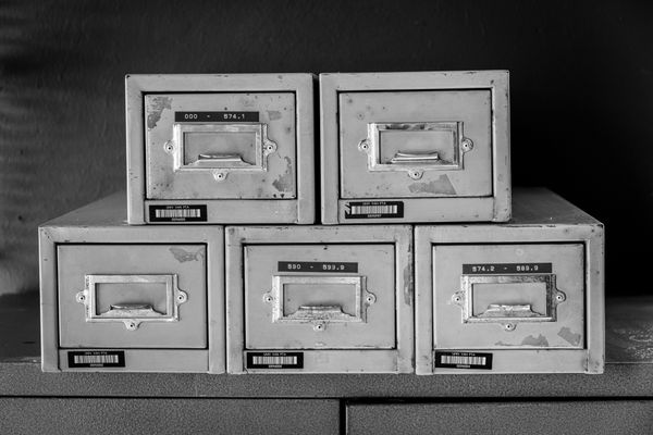 Five worn metal filing cabinets stacked against a dark wall — Magda Ehlers on Pexels
