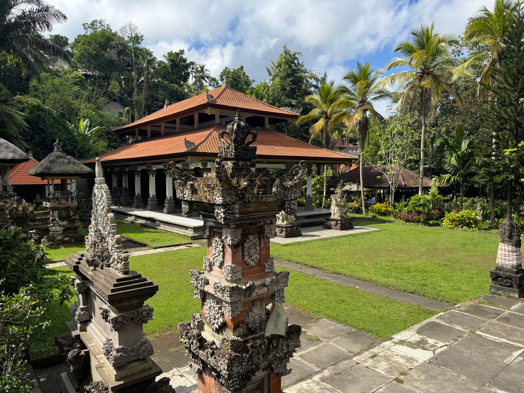 Balinese temple courtyard beside a quiet village cockfight arena after government restrictions, late afternoon light