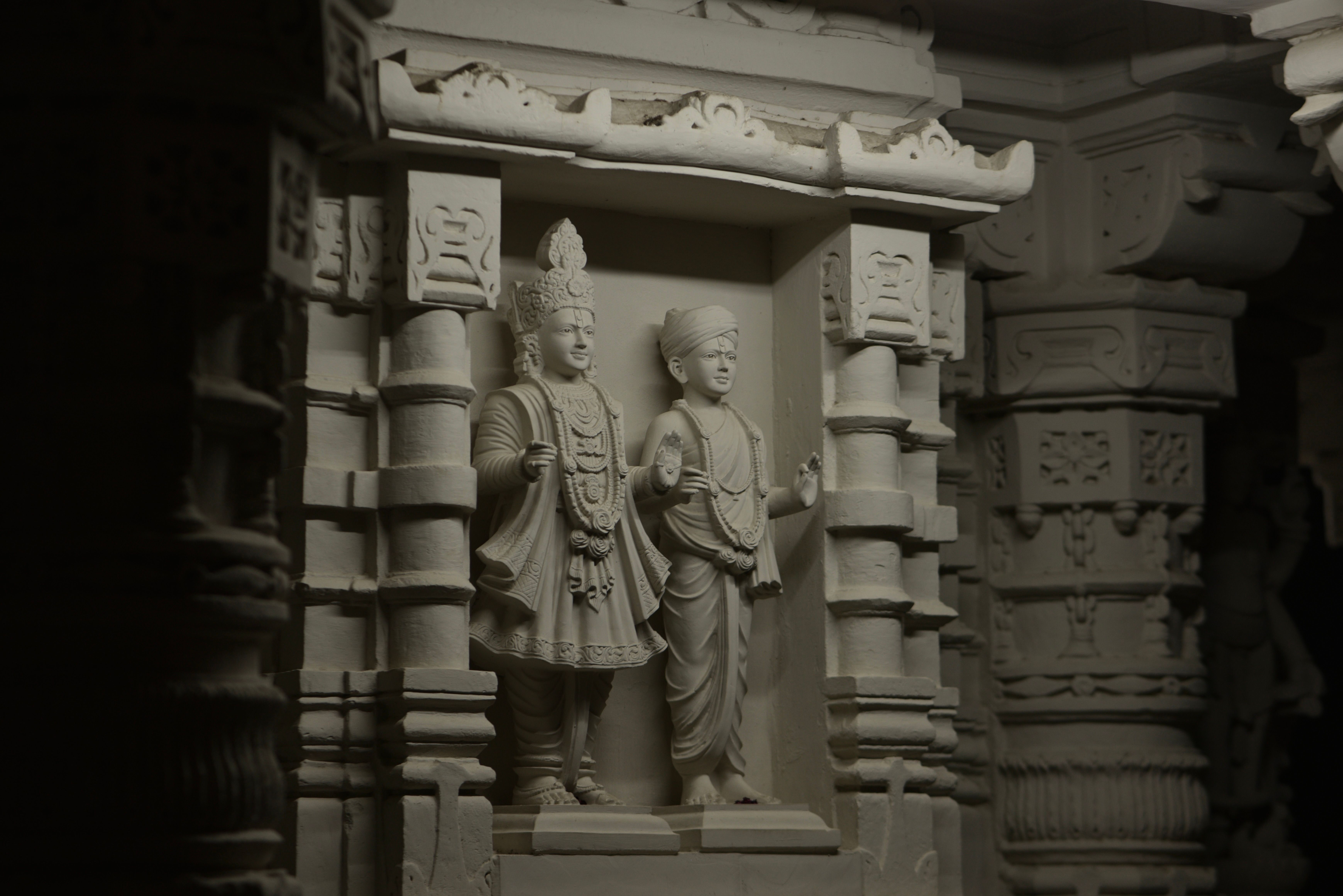 Detailed stone carvings depict figures in traditional attire inside an ancient temple.