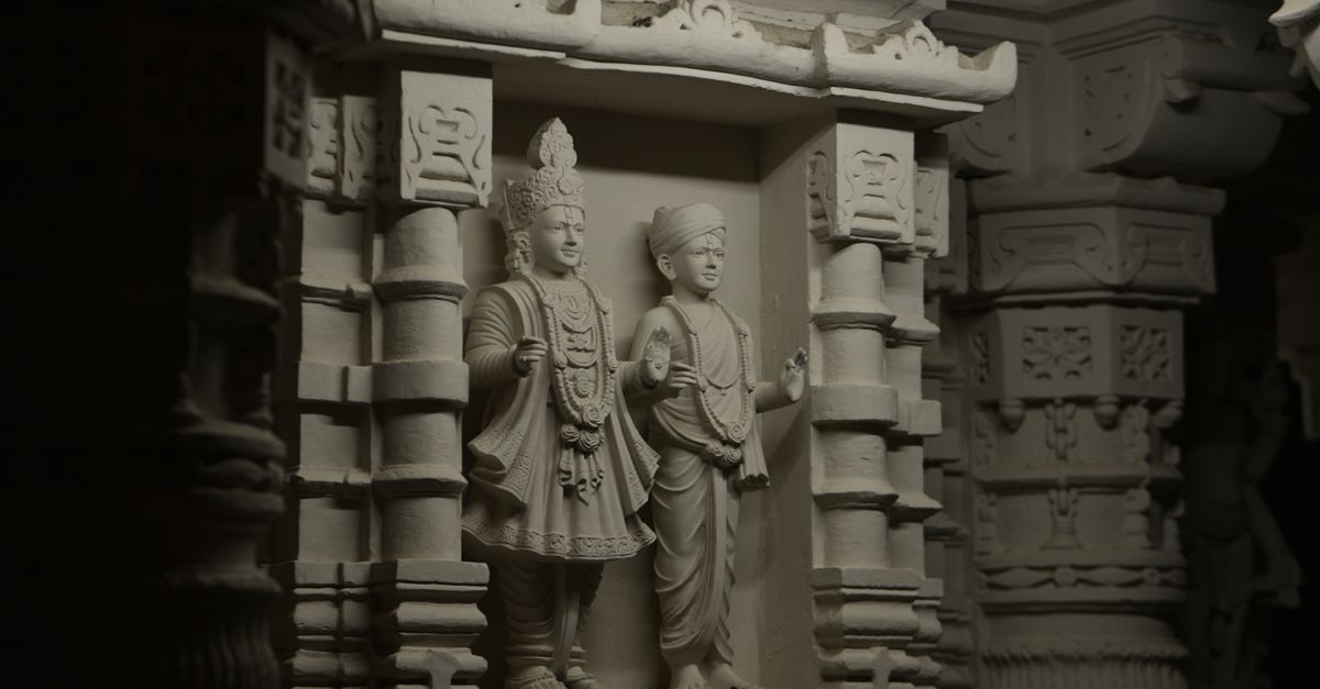 Detailed stone carvings depict figures in traditional attire inside an ancient temple.