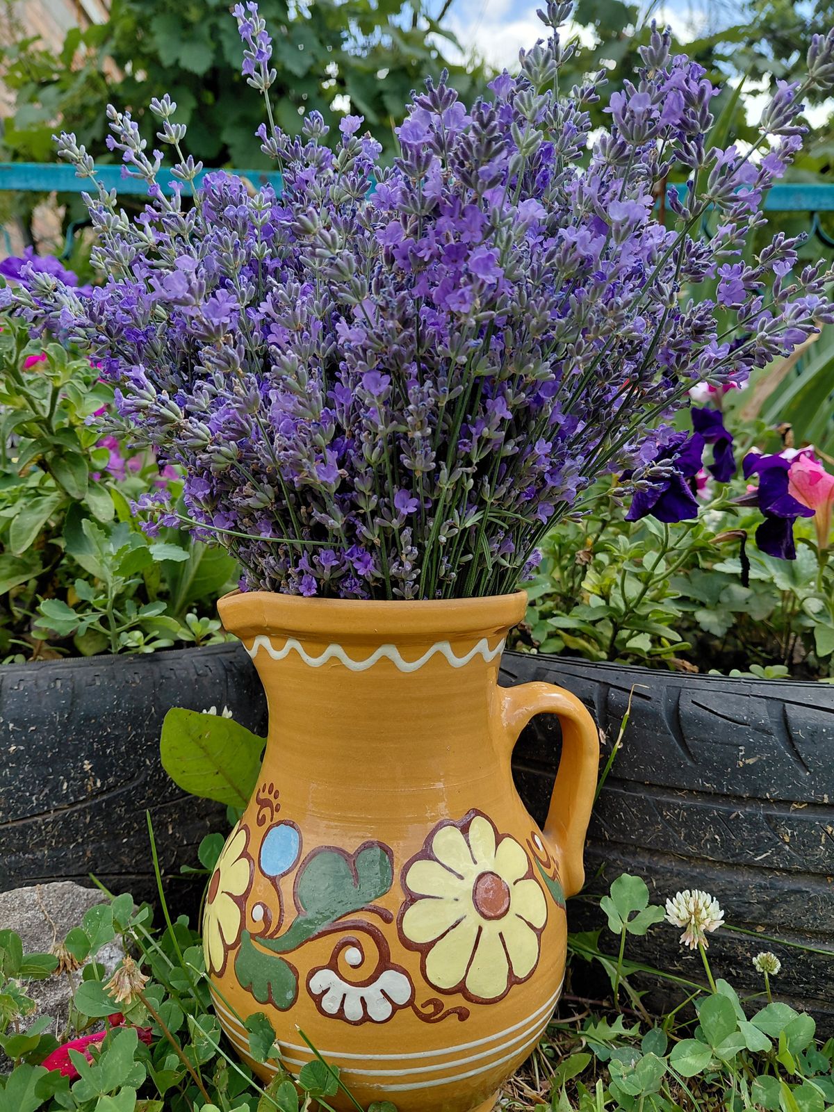 Purple lavender flowers arranged beautifully in a floral ceramic vase outdoors. Stock Photo.
