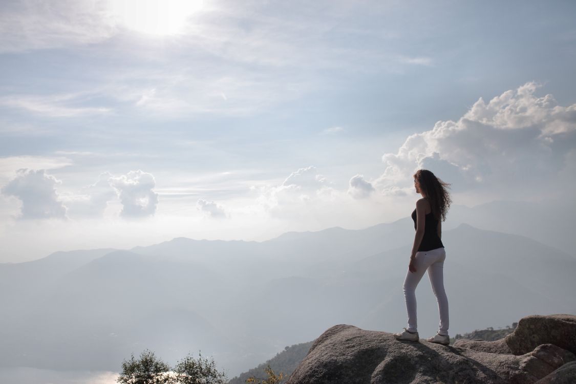 Girl Looking Over Rocks Woman Standing On A Rock Looking At Nature's View · Free Stock Photo