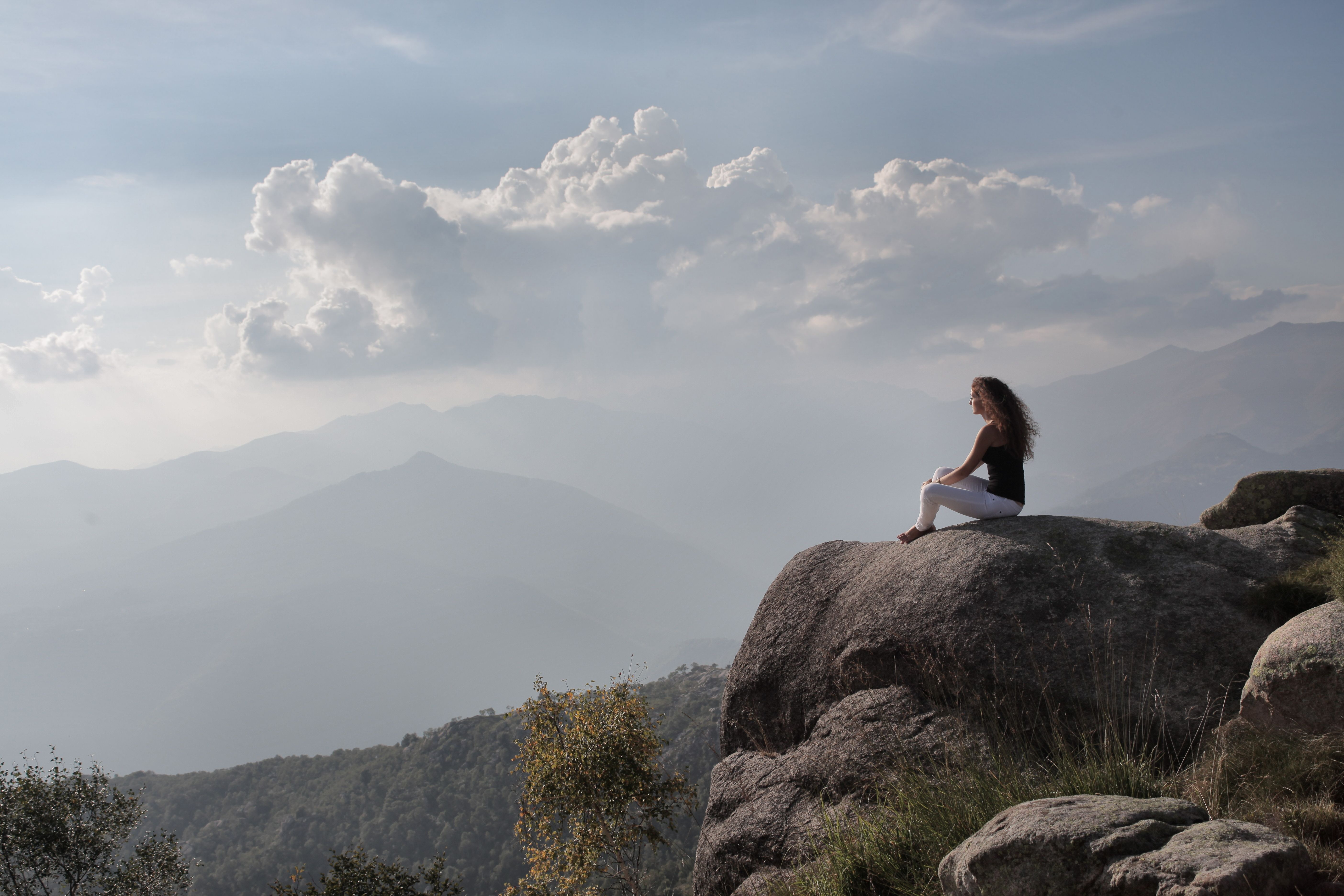 Woman in Black Tank-top and White Pants Sitting on Rock · Free Stock Photo