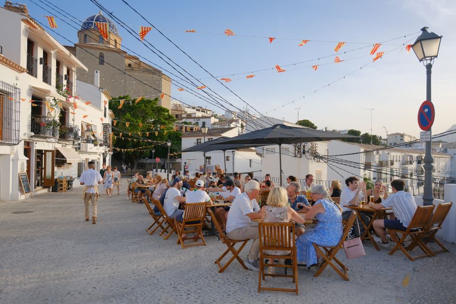 Personas disfrutando de la cena de verano al aire libre en Altea, el encantador distrito histórico de España.