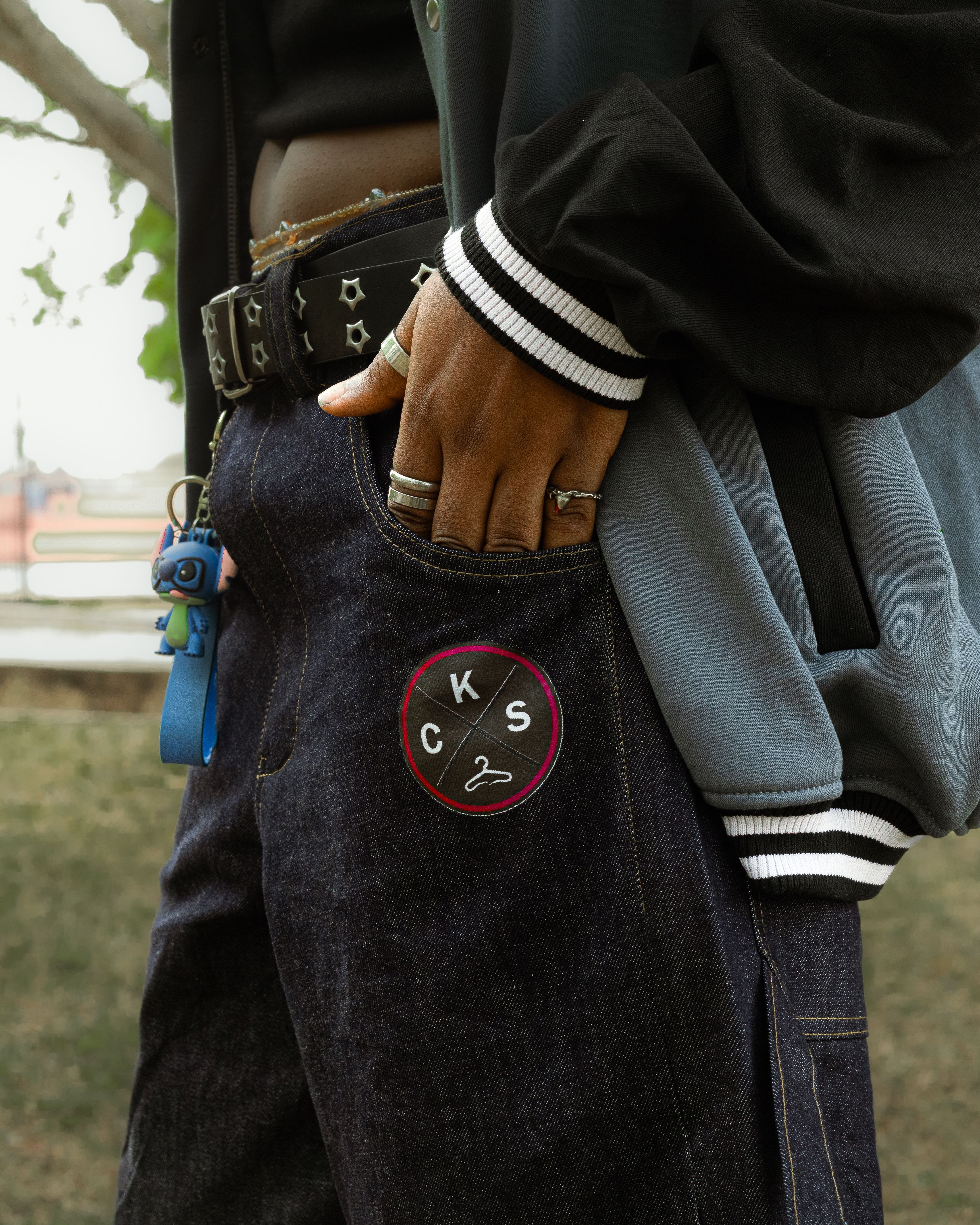 A stylish individual wearing casual urban streetwear with prominent denim jeans and a trendy jacket.