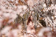春天，一名女子在公园的樱花丛中微笑