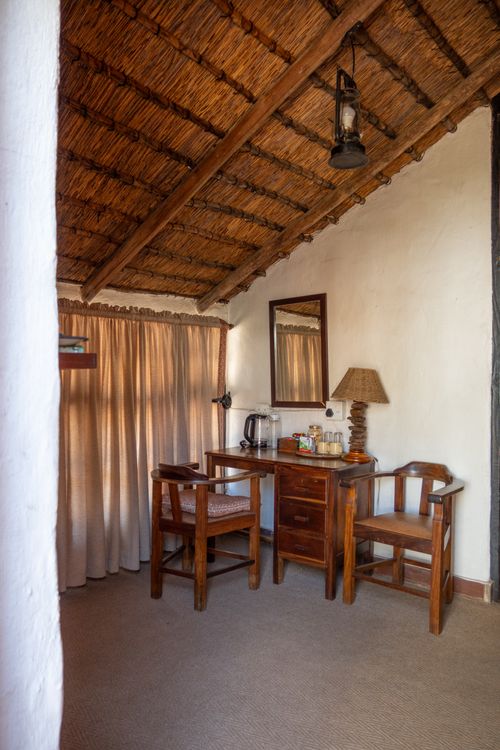Free Cozy room featuring a thatched roof and wooden furniture, perfect for a rustic getaway. Stock Photo
