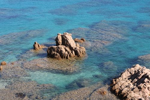 Free Tranquil coastal scene featuring clear blue water and rocky formations. Perfect for travel and nature themes. Stock Photo