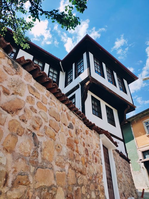 Free Charming Ottoman-style house with stone wall under a bright blue sky in Kastamonu, Türkiye. Stock Photo