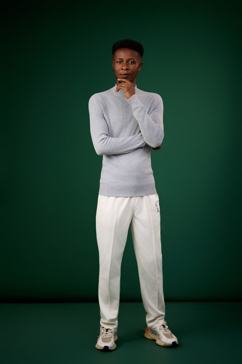 Free Stylish young adult in casual attire posing confidently against a green background. Stock Photo