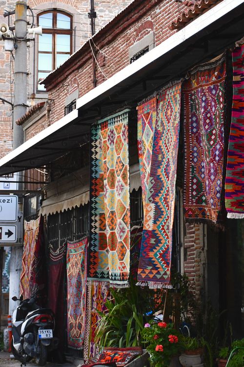 Free Vibrant display of traditional Turkish rugs in an outdoor street market setting. Stock Photo