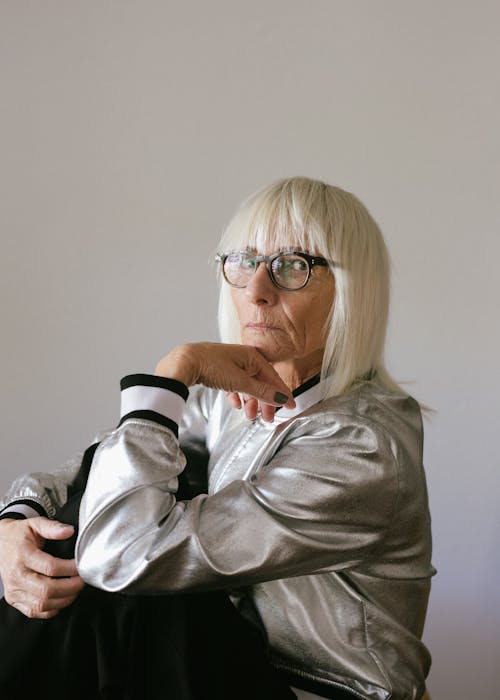 Senior woman in eyeglasses and silver jacket