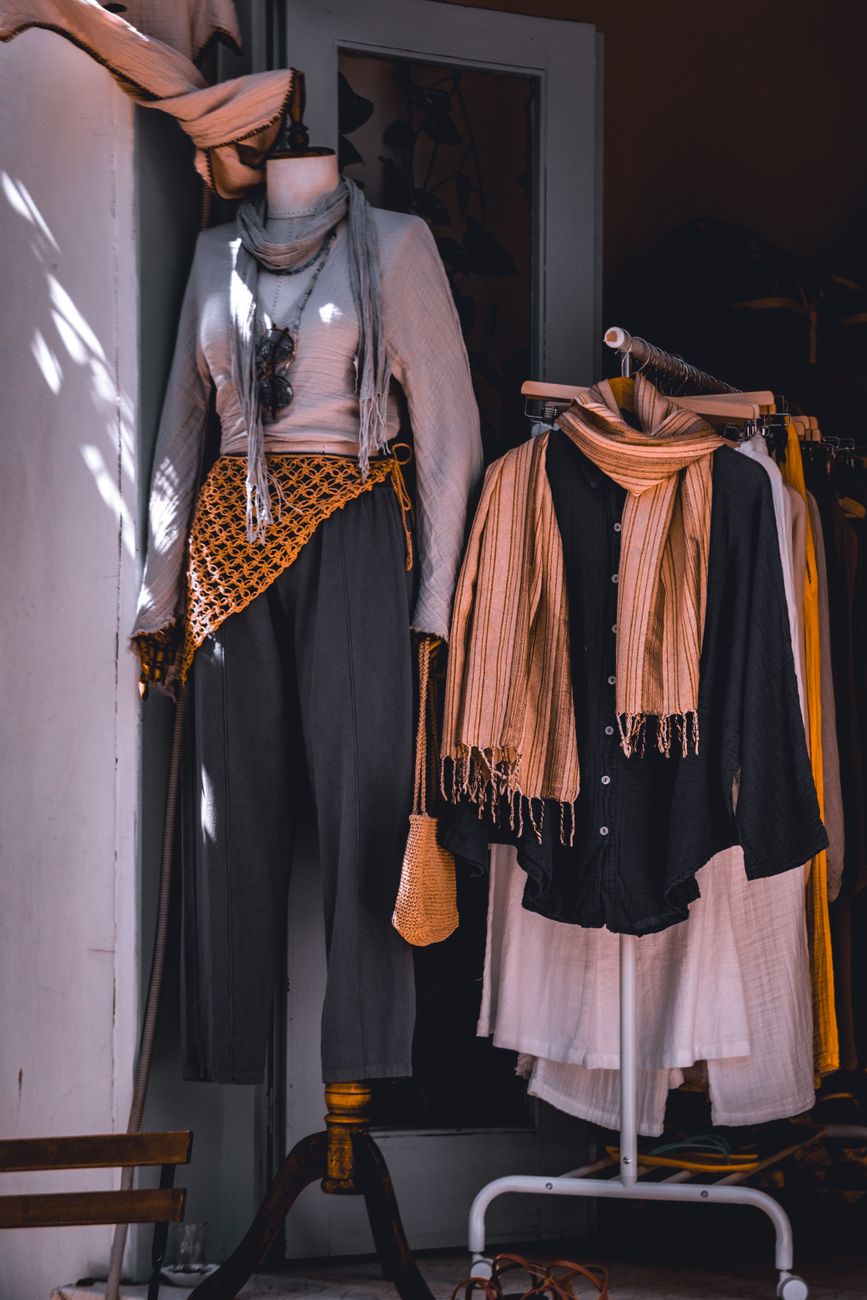 Fashionable clothing display with scarves in a boutique setting, showcasing modern style.