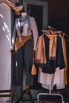 Fashionable clothing display with scarves in a boutique setting, showcasing modern style.