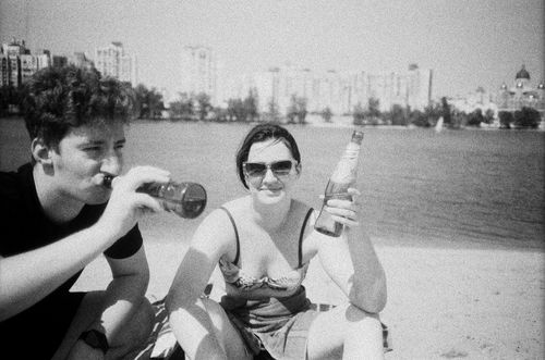 Free Two friends enjoying drinks by the beach in a vintage black and white photo. Stock Photo