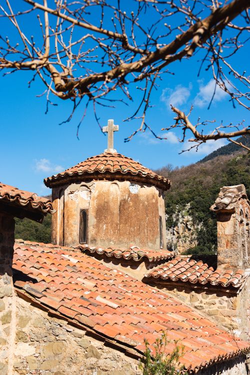 Free Beautiful view of a historic chapel with terracotta roof tiles in Greece under a clear blue sky. Stock Photo