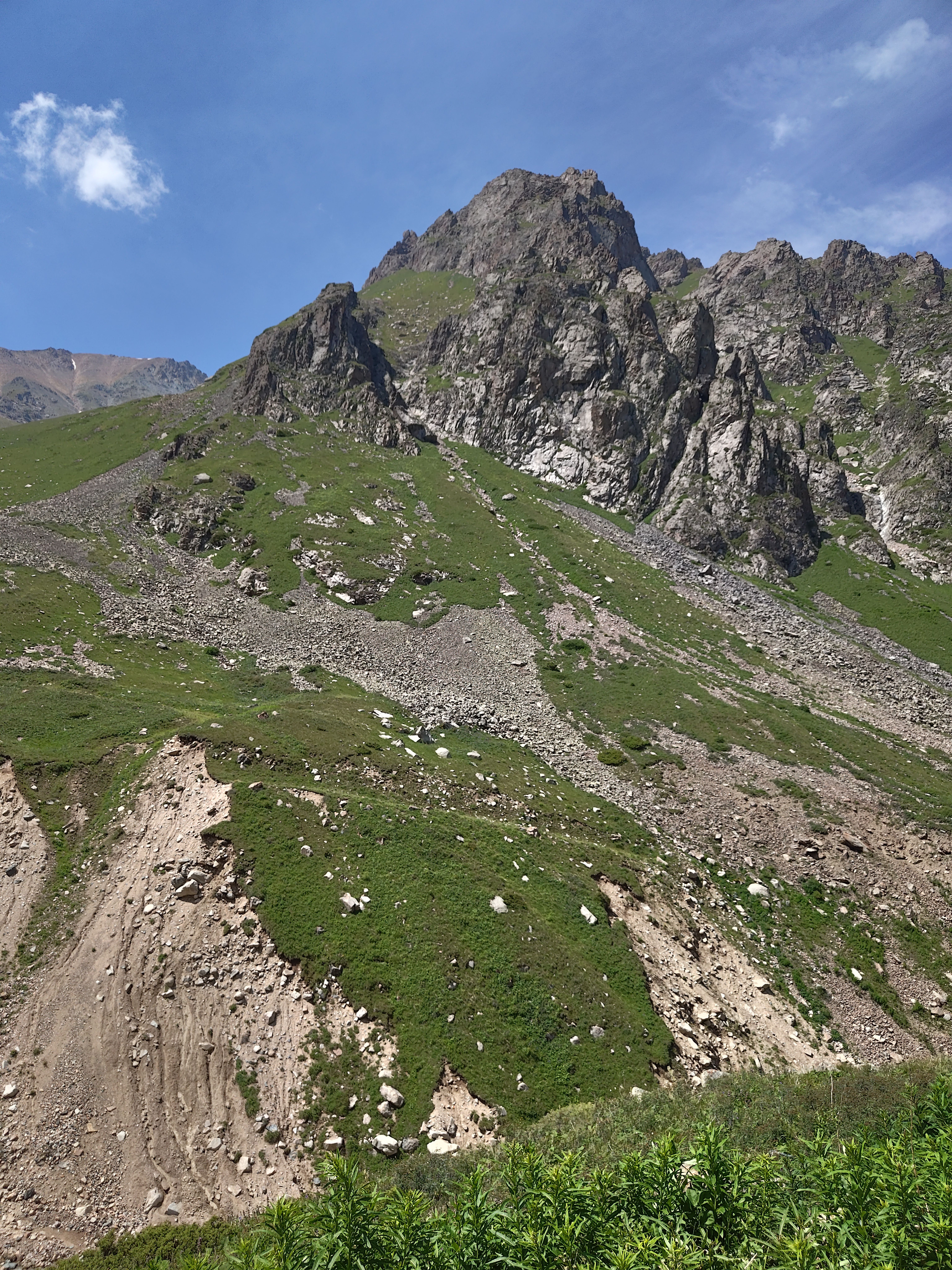 Dramatic rocky mountain peak in Almaty, Kazakhstan under clear blue sky.