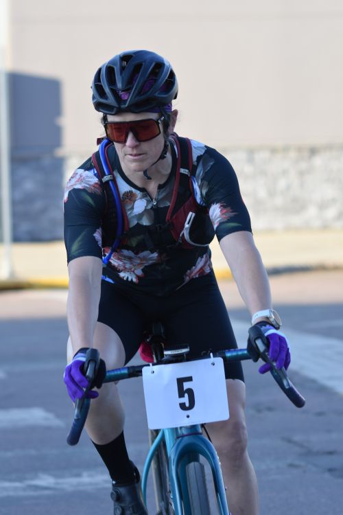 Free Focused cyclist number 5 in vibrant attire competes in a road race outdoors. Stock Photo