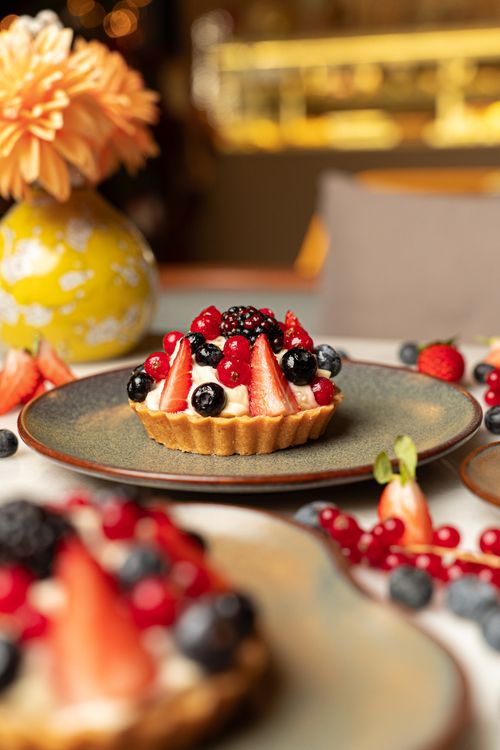 Free A close-up of a berry tart topped with fresh strawberries, blueberries, and raspberries. Stock Photo