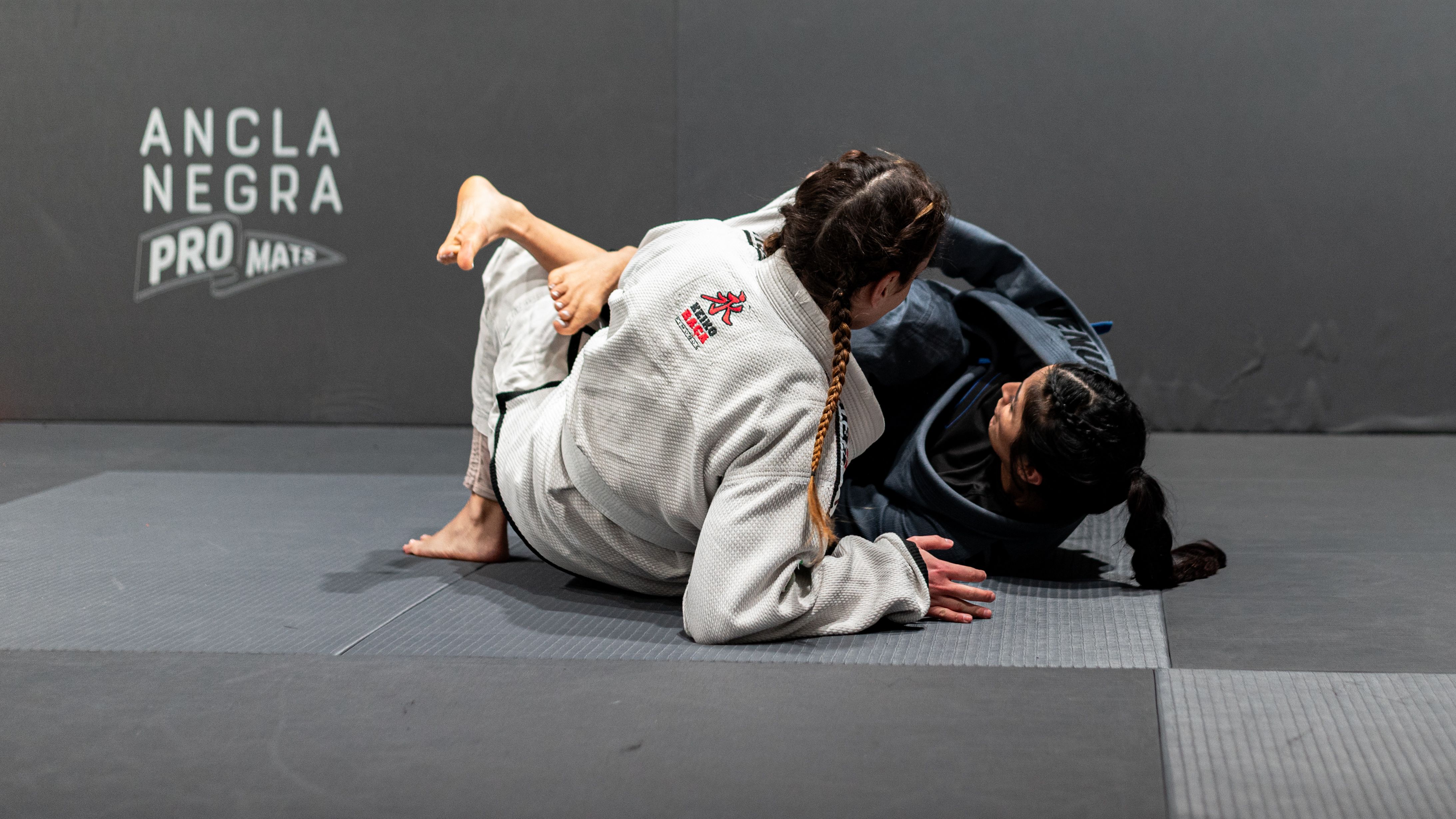 Two women engaged in Brazilian Jiu-Jitsu sparring at a dojo. Shot in Buenos Aires.