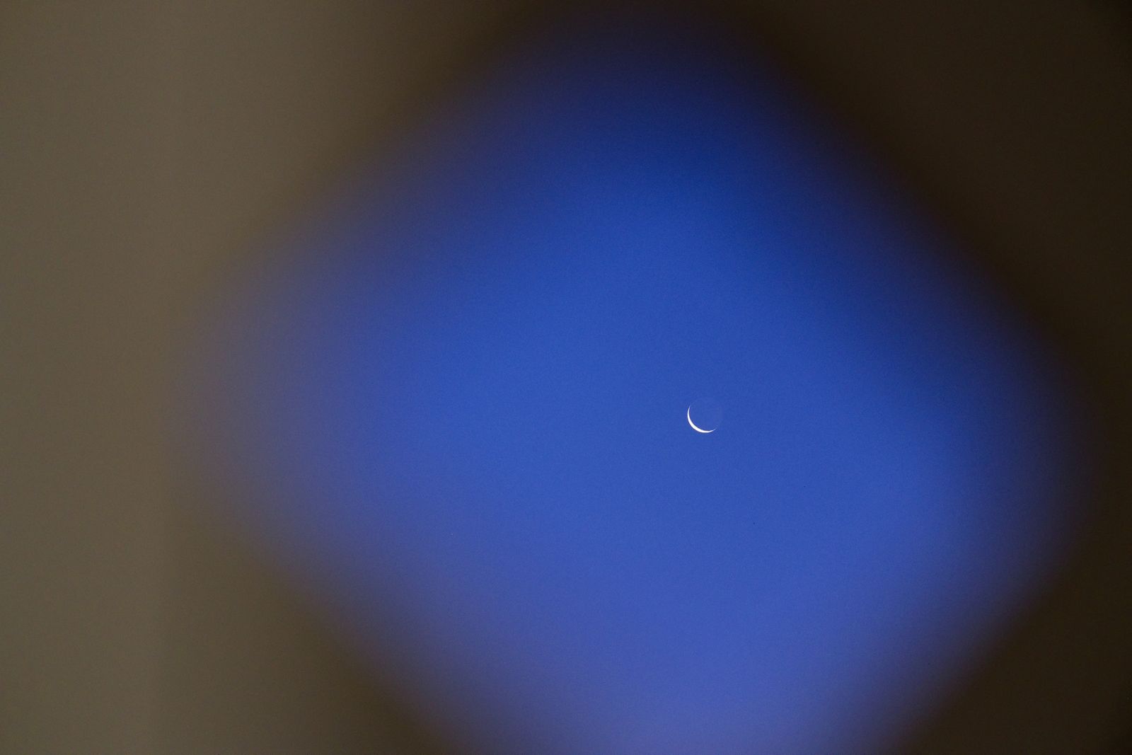 Croissant de lune encadré par une silhouette floue en forme de losange