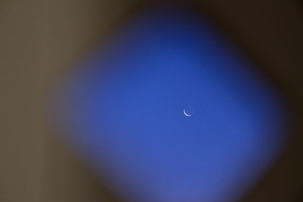 Croissant de lune encadré par une silhouette floue en forme de losange