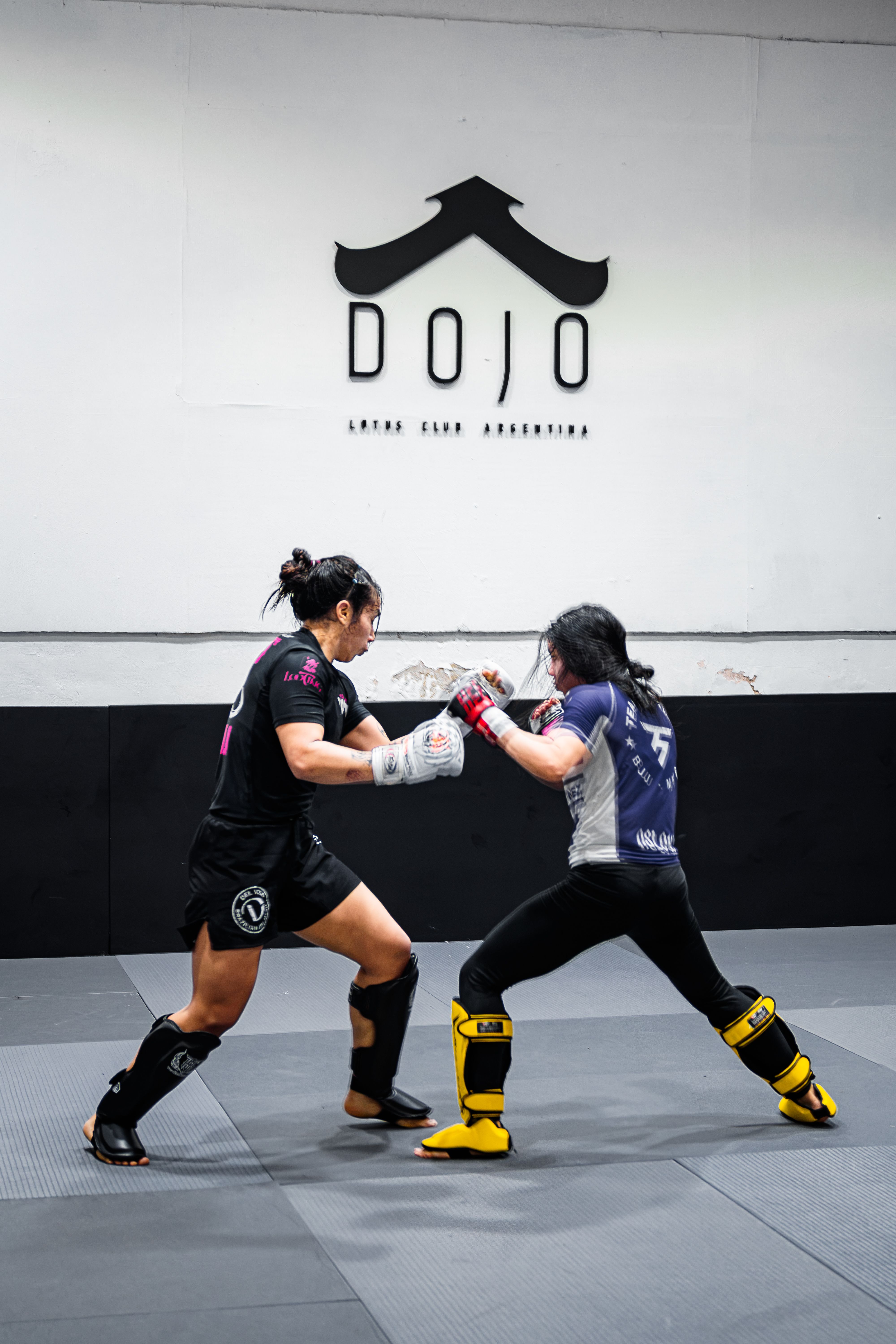 Two female fighters sparring in a mixed martial arts dojo in Buenos Aires.