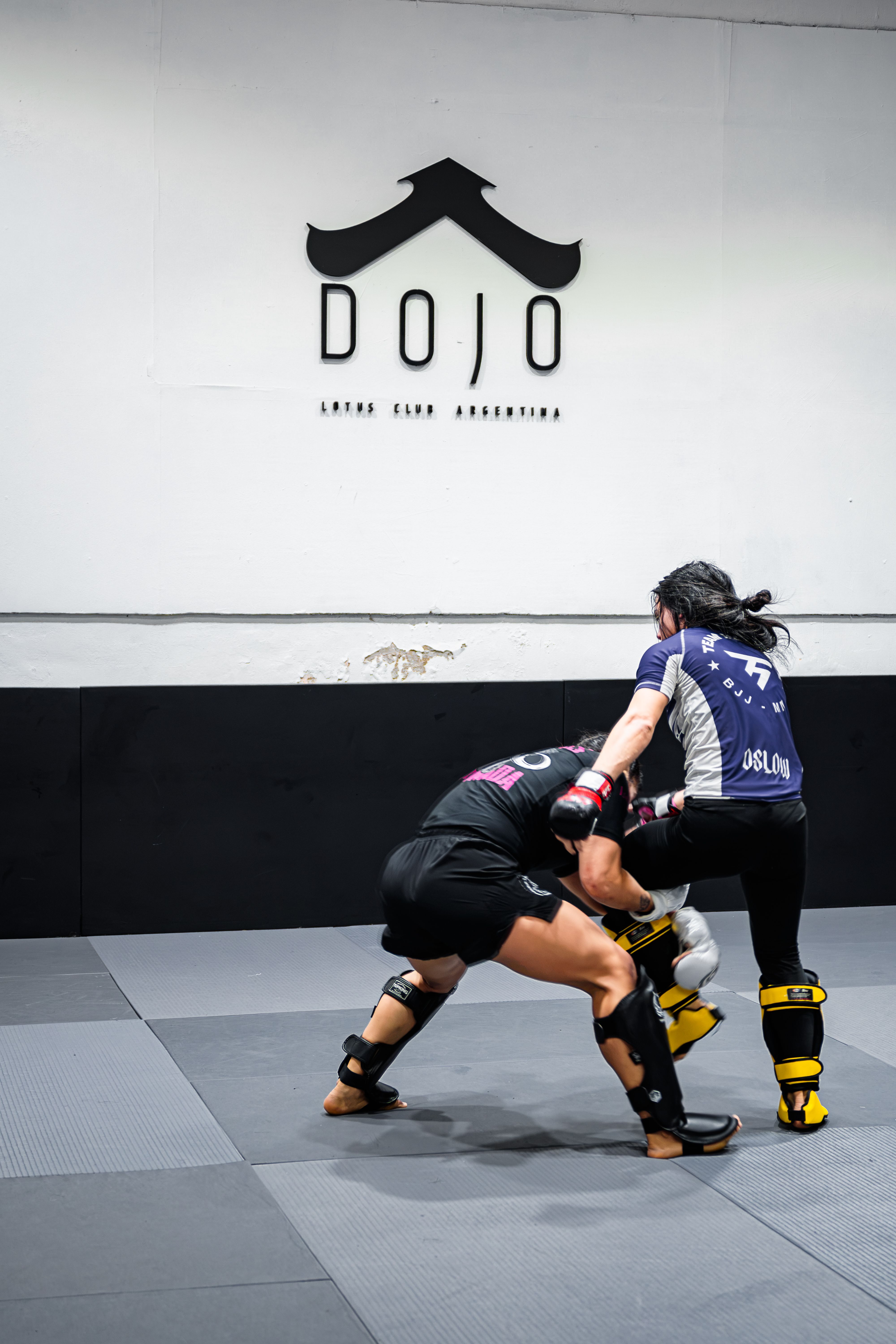 Intense mixed martial arts training session observed at a dojo in Buenos Aires, Argentina, showcasing technique and focus.