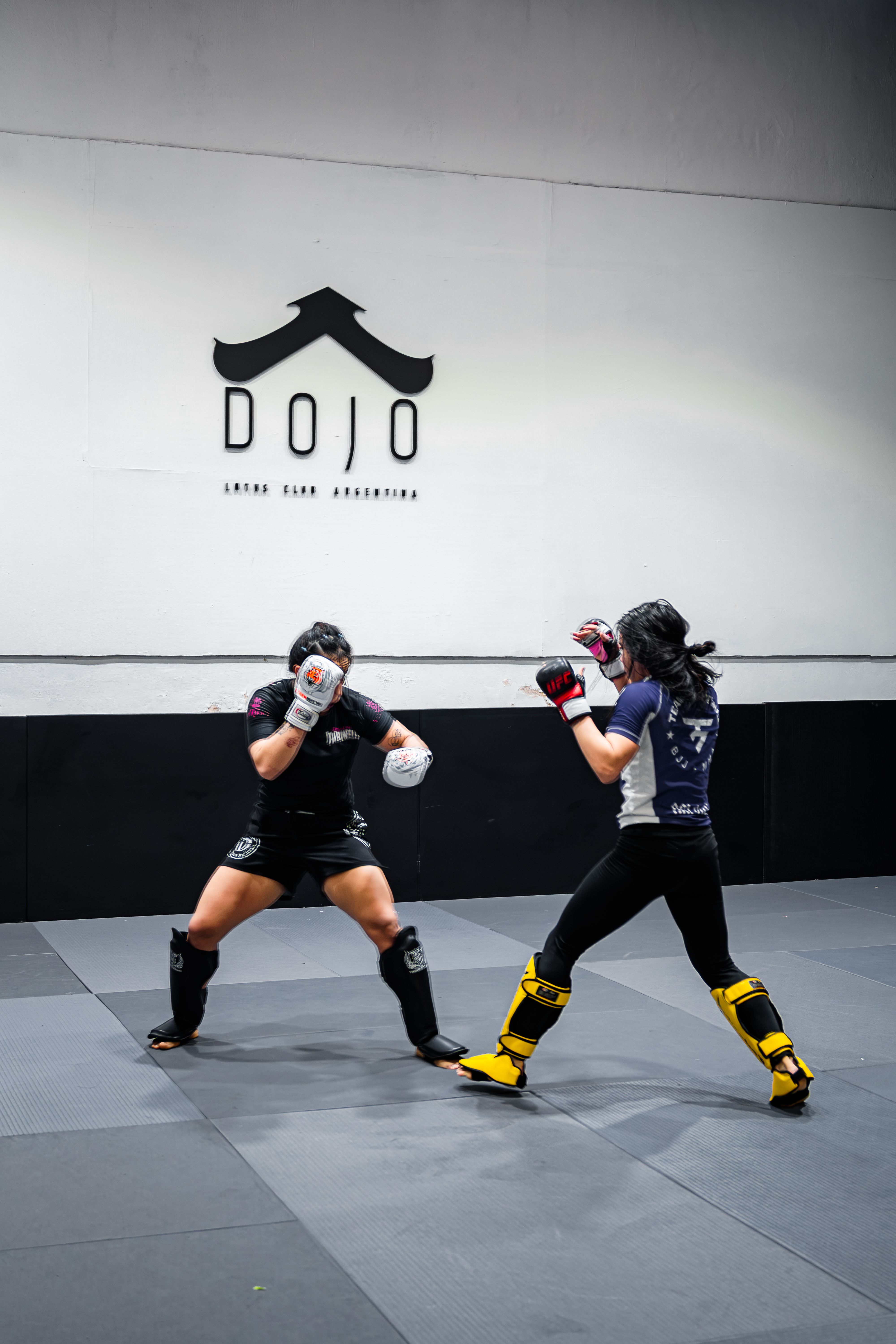 Two martial artists engage in a focused training session at a dojo in Buenos Aires, Argentina.