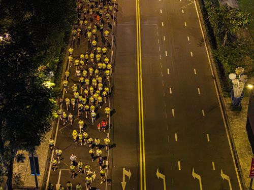 Free Aerial view of runners participating in a nighttime marathon on a city street. Stock Photo