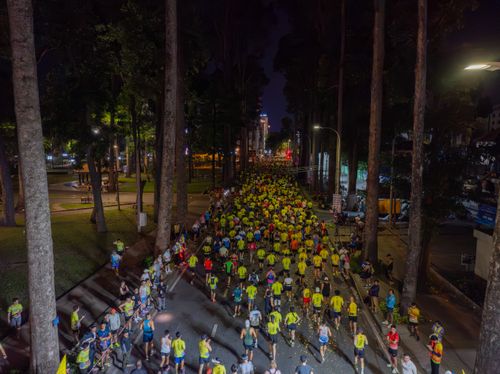 Free Aerial shot of a nighttime marathon with a large crowd of runners. Stock Photo