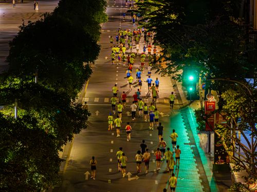 Free Crowd of marathon runners at night from above, showcasing urban city life. Stock Photo