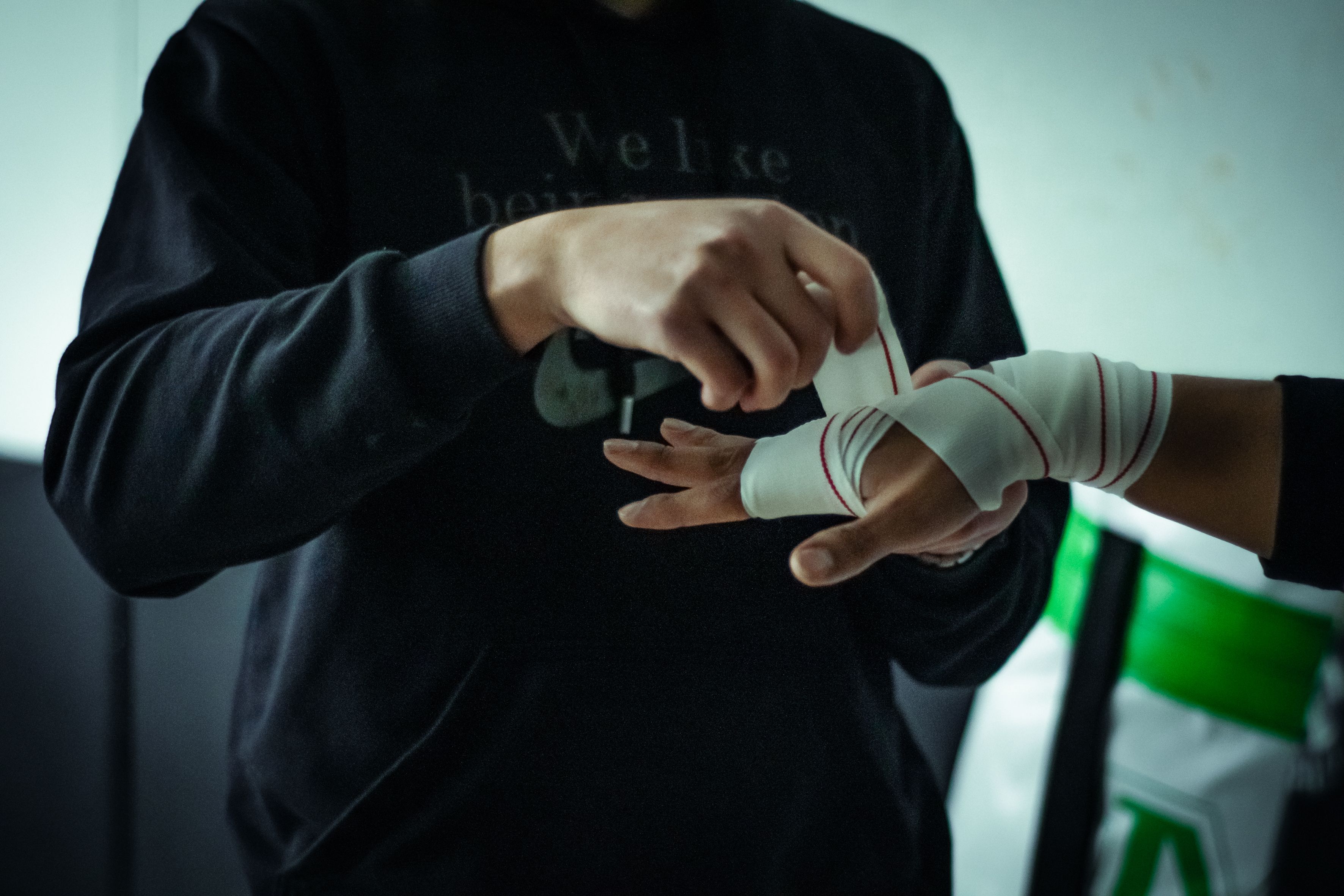 Close-up of hands wrapping for boxing training. Intense focus on preparation and technique.