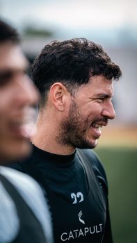 Close-up of an athlete smiling during a sunny outdoor training session.