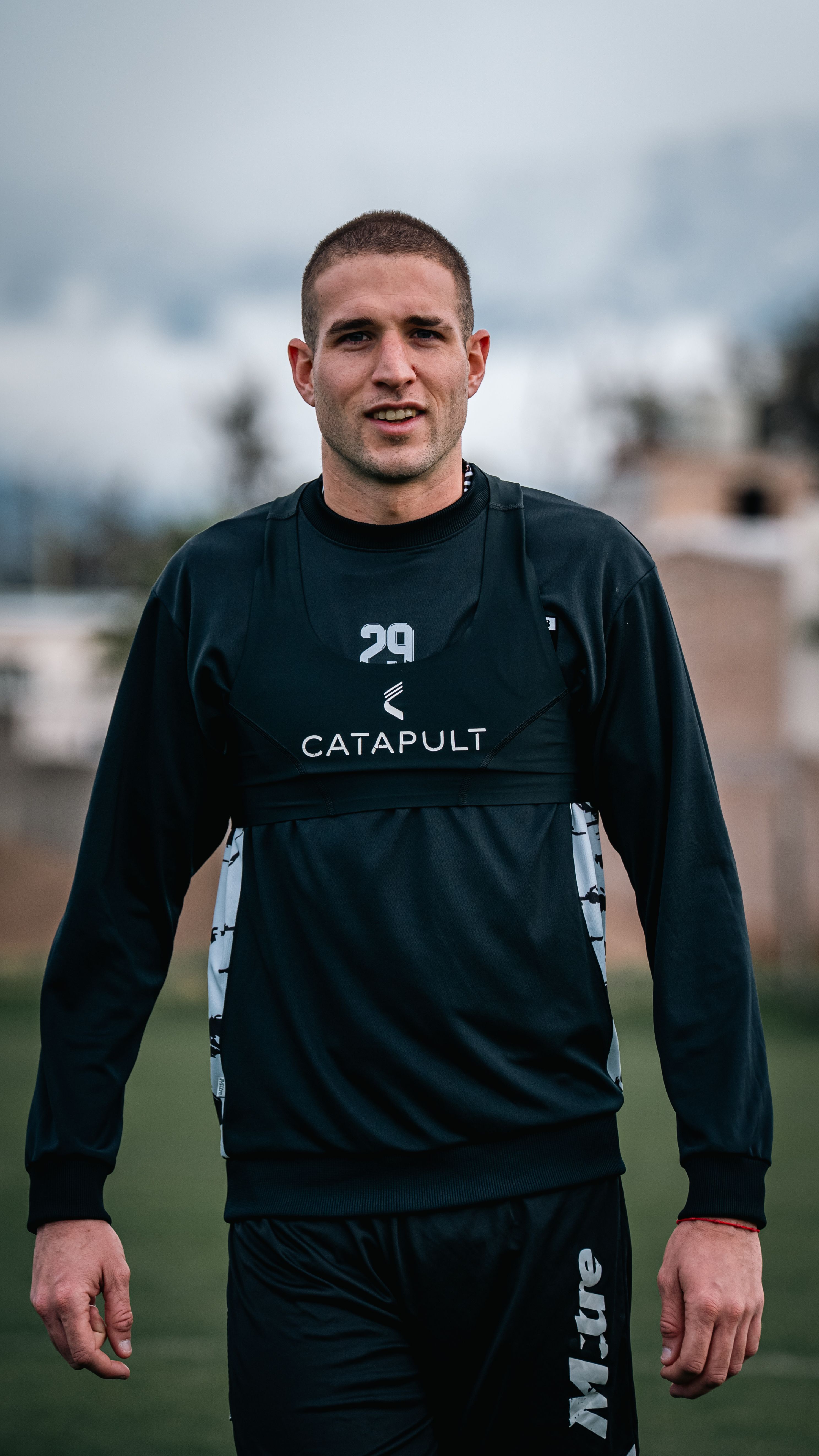 Portrait of a male athlete training outdoors in sportswear with a focus on fitness and determination.