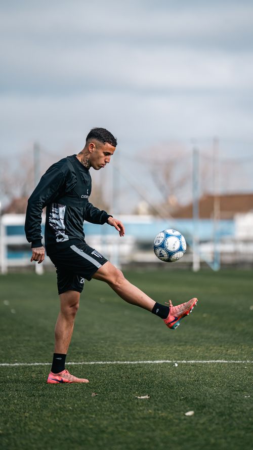 Free A young man practicing soccer skills on a green field during the day. Stock Photo