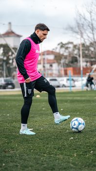 Soccer player in a pink vest during training on a grassy field, showcasing skills.