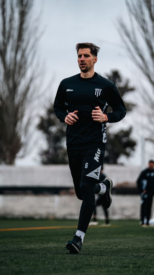Free A male athlete in sportswear running on a grassy sports field during daytime. Stock Photo