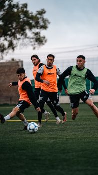 A group of young soccer players in training on a green field. Focus on energy and teamwork.